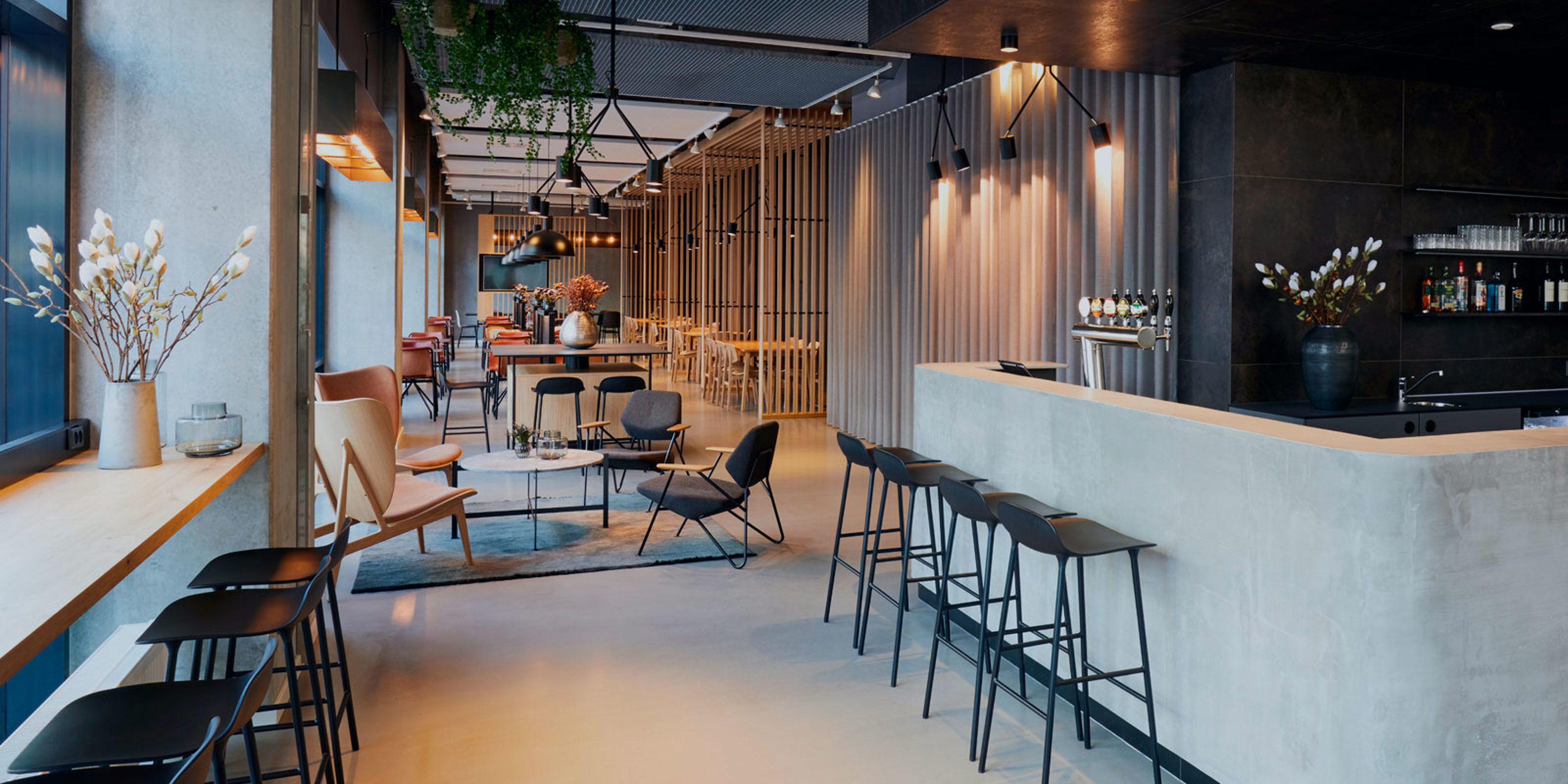 Stylish café interior with black bar and elegant chairs in a bright and inviting space at Zleep Hotels Lounge.