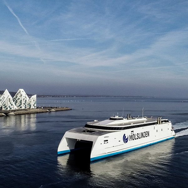 Molslinjen ferry Express 3 sails near the coast with iconic architecture visible in the background.