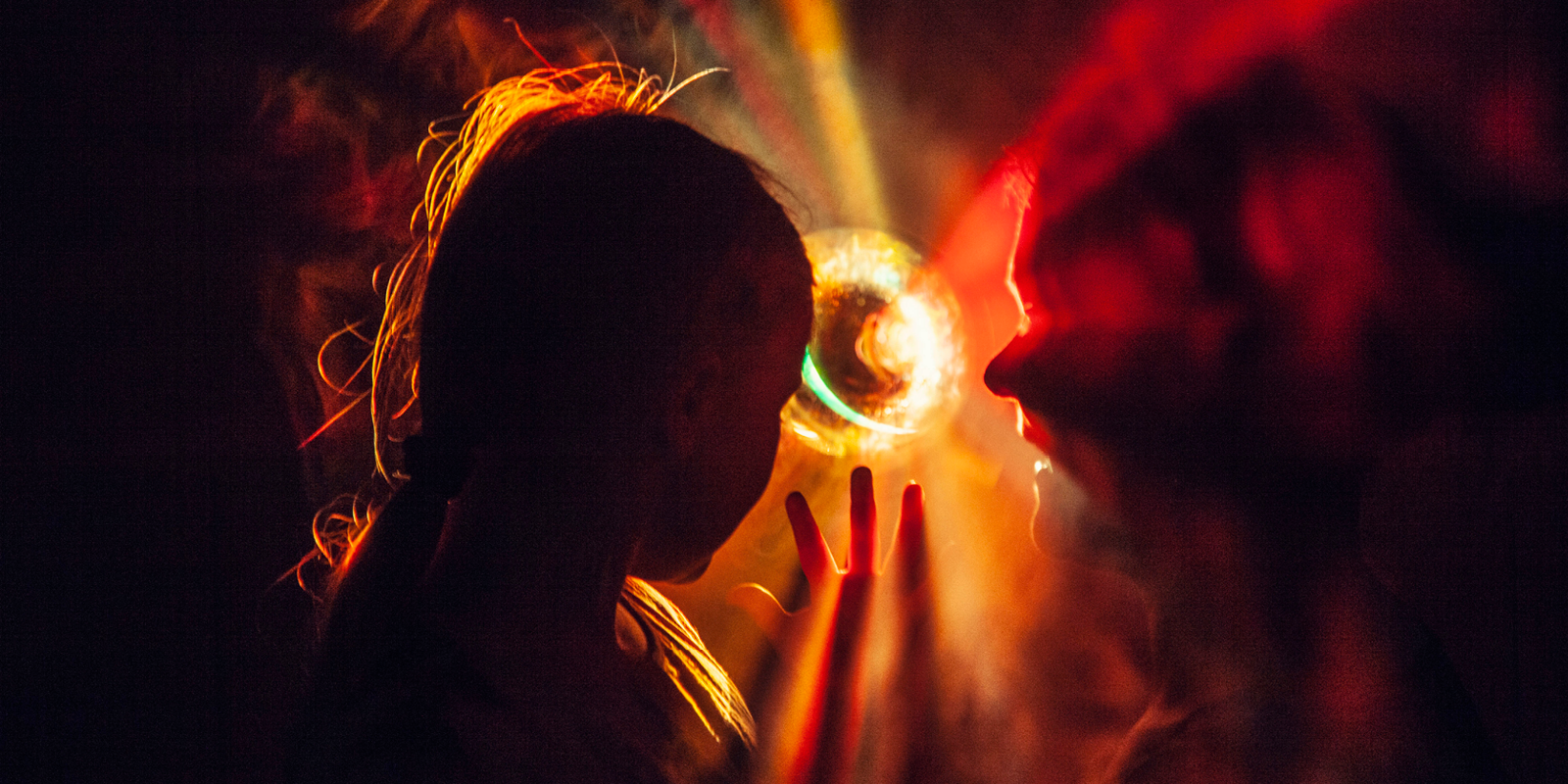 Silhouettes of two people in warm, colorful light creating a dreamy atmosphere with fascinating light patterns.
